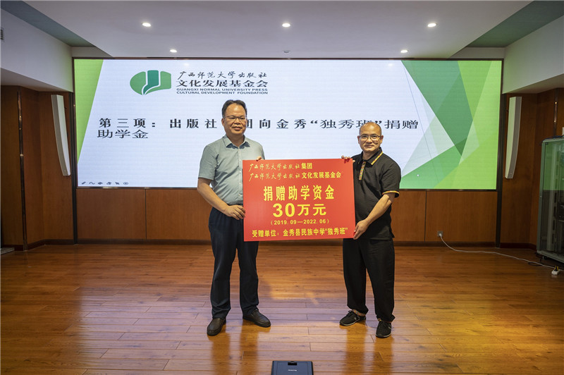 廣西師范大學(xué)出版社集團黨委書(shū)記、董事長(cháng)黃軒莊（左一）代表出版社向金秀民族中學(xué)“獨秀班”資助30萬(wàn)元（李顯楊攝）.jpg