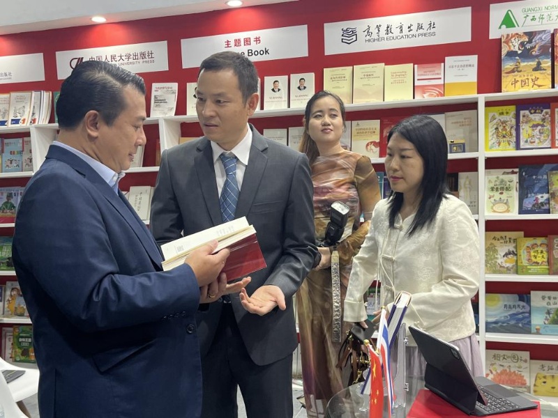 泰國書(shū)商和出版商協(xié)會(huì )主席蘇維奇（左一）在翻閱《近鏡頭：溫暖的瞬間》。（盧雯 攝）jpg_副本.jpg