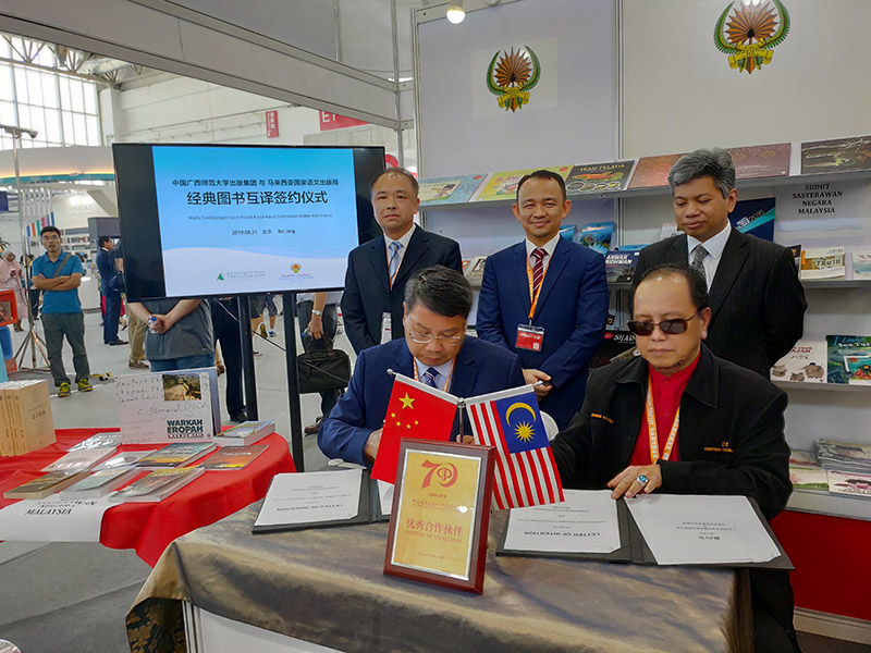 廣西師范大學(xué)出版社集團黨委書(shū)記、董事長(cháng)張藝兵（左前一）與馬來(lái)西亞國家語(yǔ)文出版局理事長(cháng)Datuk Abang Sallehuddin Abang Shokeran簽訂合約（陳子鋒攝）.jpg