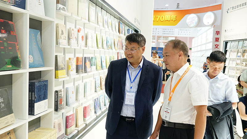 集團公司黨委書(shū)記、董事長(cháng)張藝兵向校黨委副書(shū)記趙鐵詳細介紹出版社圖書(shū)（陳子鋒攝）.JPG